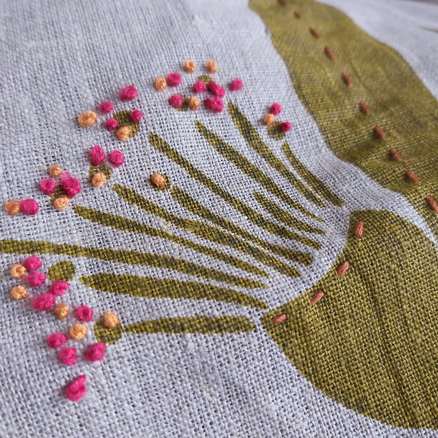 Hand cut stencil of a gumnut flower with embroidery.