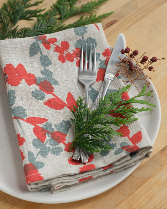 Linen napkins screen printed with Wattle Sprigs in Guava and Storm. Designed and screen printed by Femke Textiles.