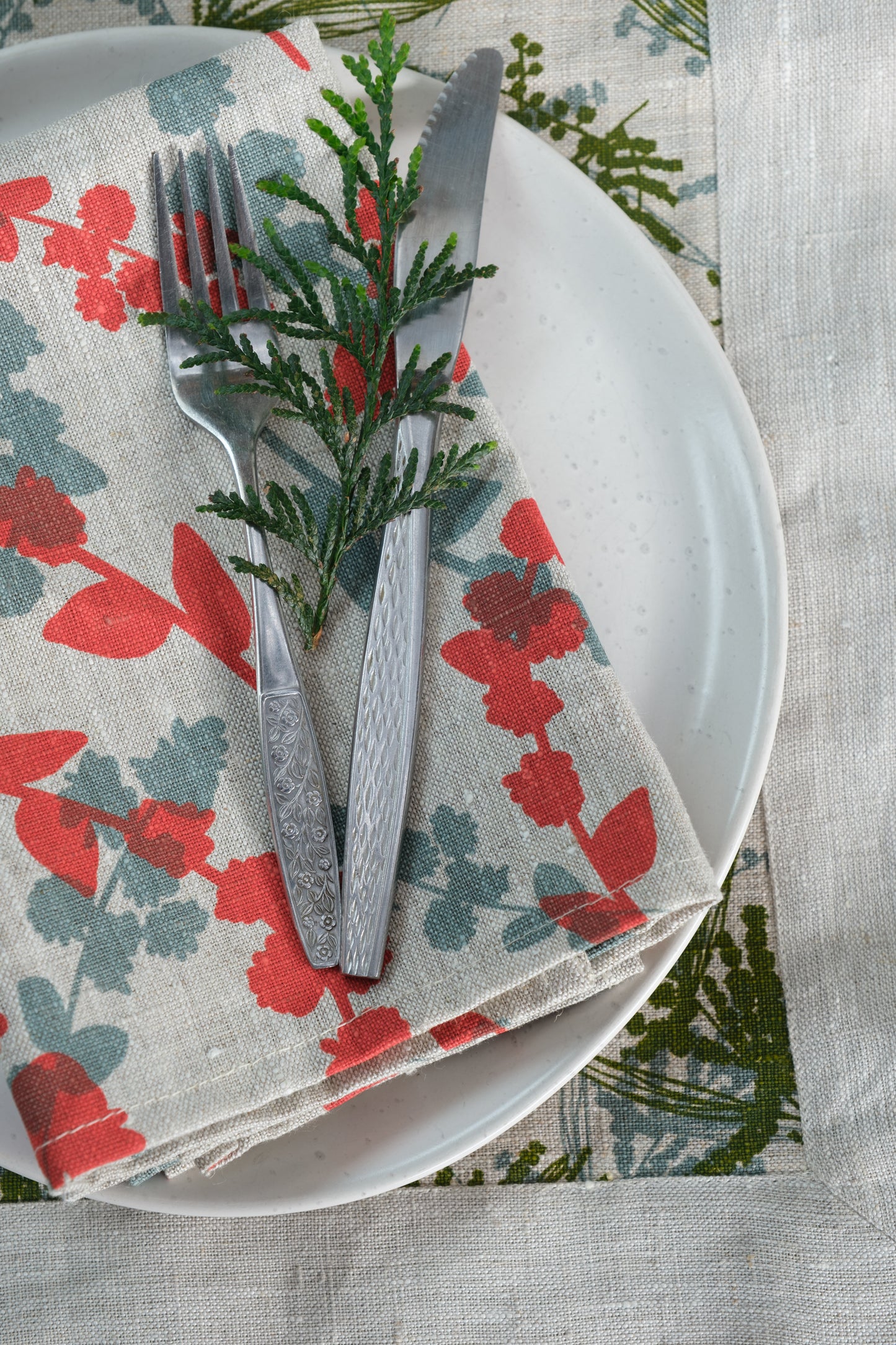 Linen napkins screen printed with Wattle Sprigs in Guava and Storm. Designed and screen printed by Femke Textiles.