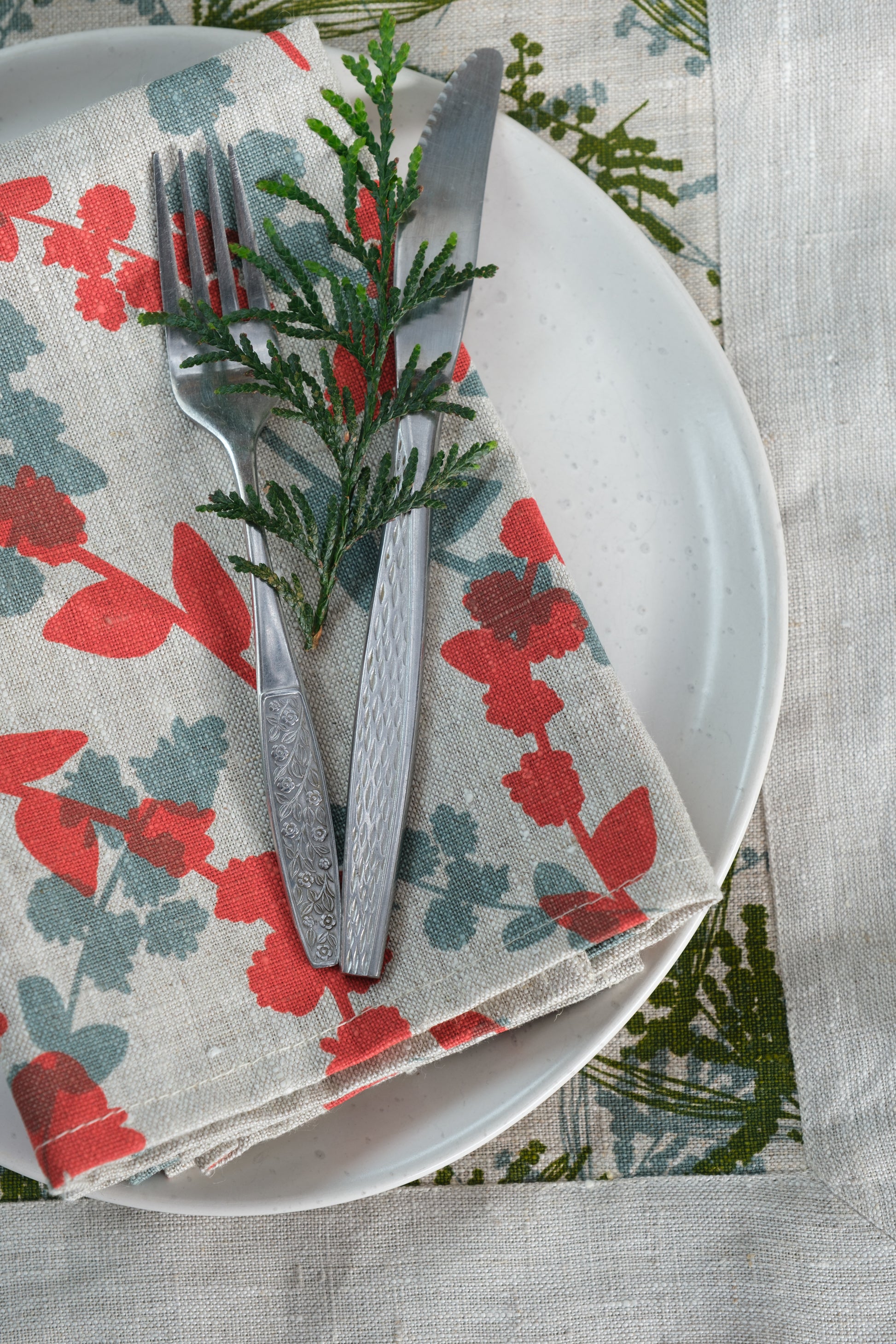 Linen napkins screen printed with Wattle Sprigs in Guava and Storm. Designed and screen printed by Femke Textiles.