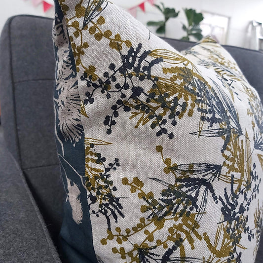 A linen cushion cover featuring mixed wattle print in olive oil and indigo and Forager's Delight print in indigo. Designed and printed and made by Femke Textiles.