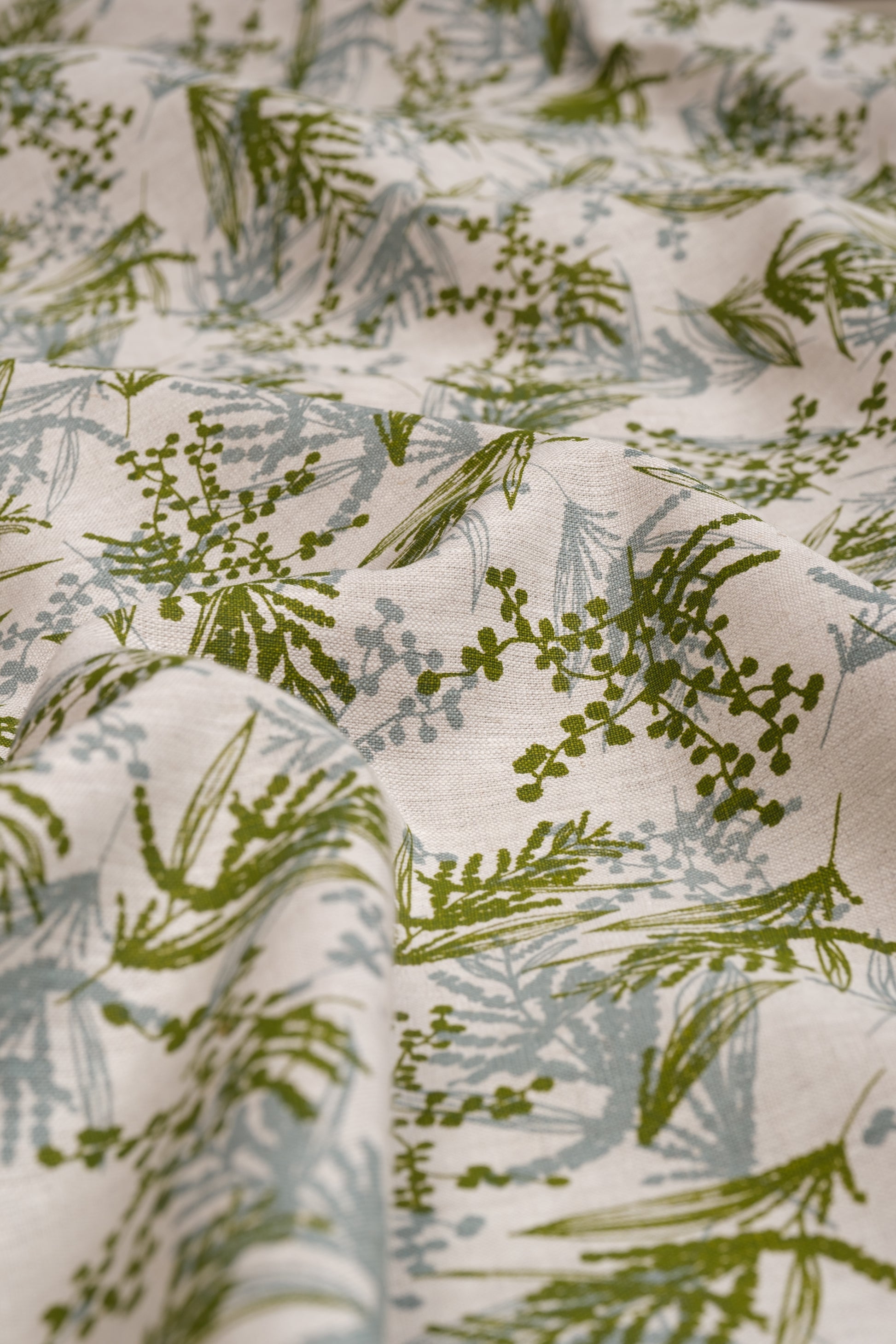 Screen printed linen fabric with a wattle print in storm and moss. Designed and printed by Femke Textiles. Base oatmeal flax linen.