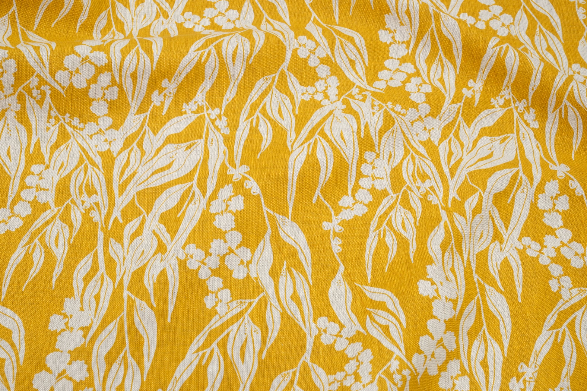 Screenprinted linen fabric by Femke Textiles featuring Nuts about Wattle in Mustard on an oatmeal linen.